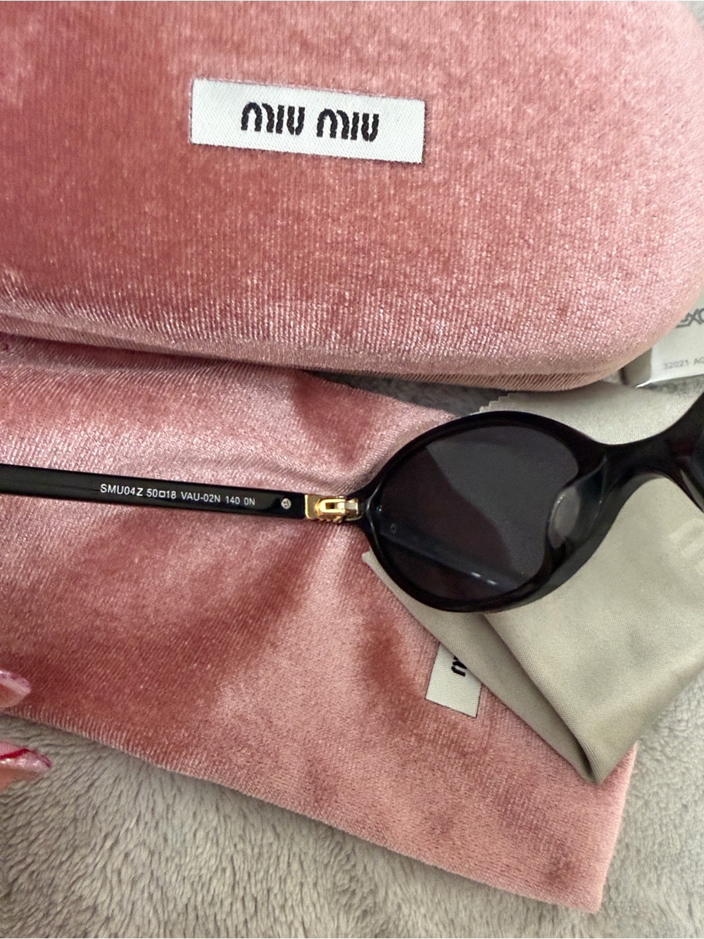 Miu Miu Black Oval Sunglasses with Subtle Gold Detail
